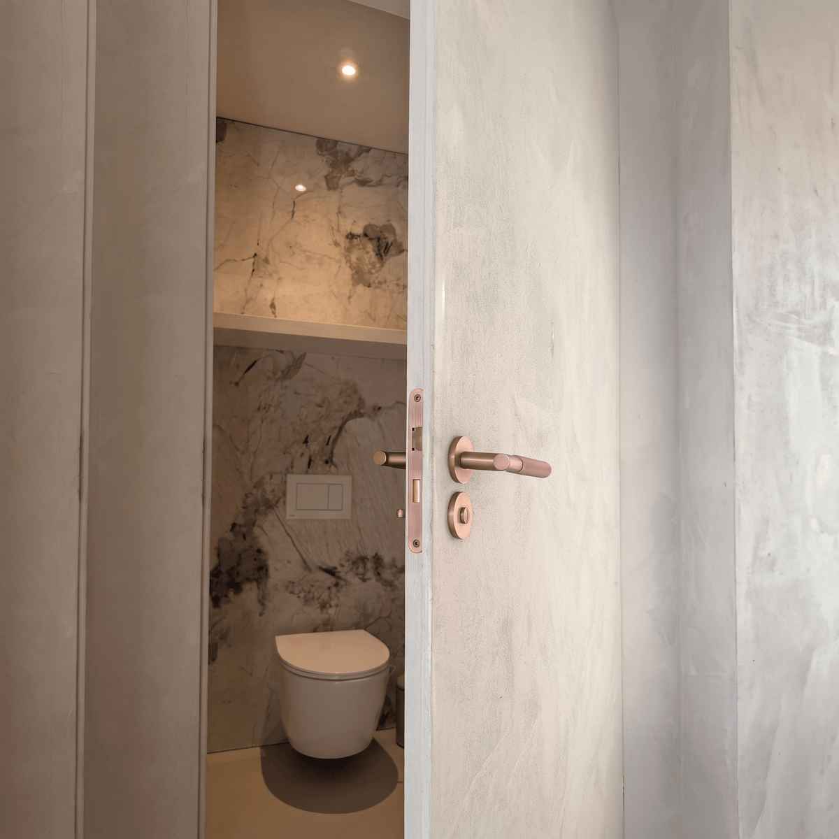 Rond WC-rozet Arzana in koper op een toiletdeur